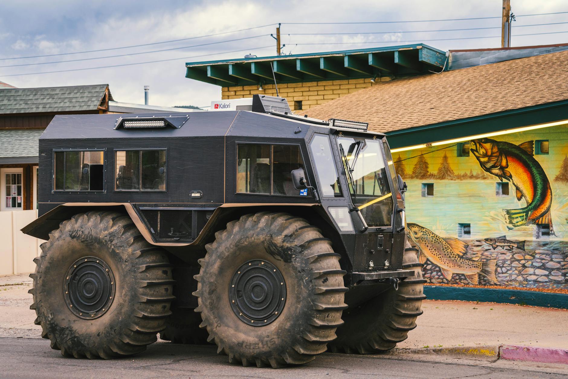 Pojazd terenowy z ponadgabarytowymi oponami zaparkowany przy drodze