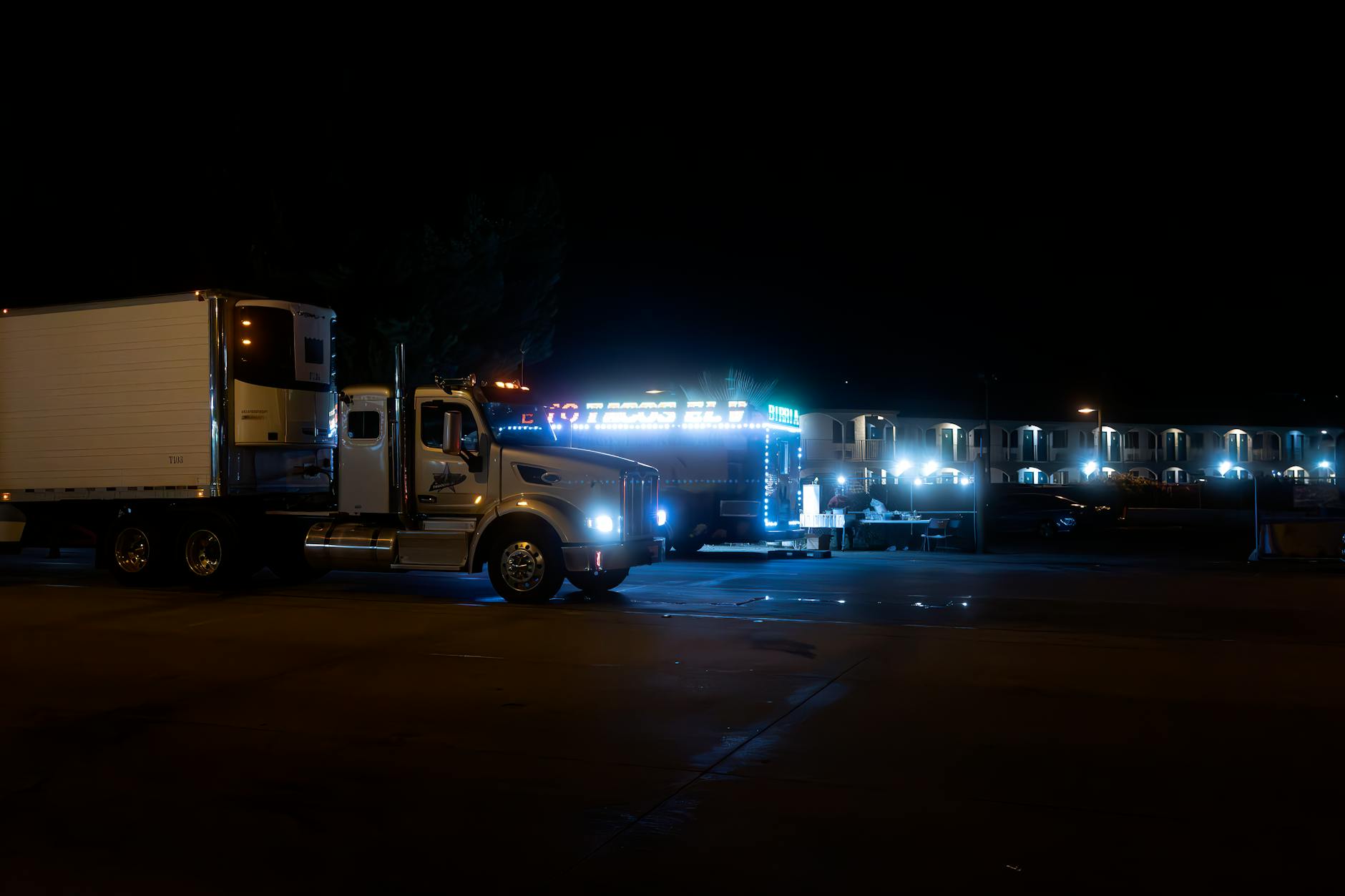 Dwa nocą oświetlone ciężarowe zestawy w mieście podczas postoju