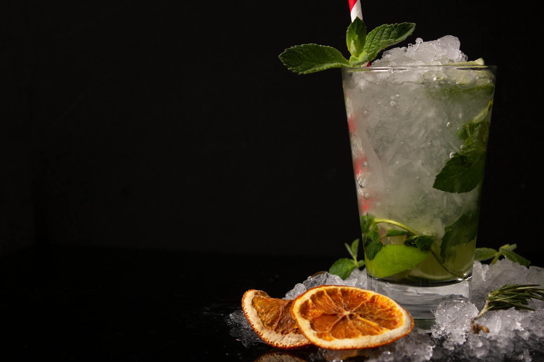 Koktajl mojito z miętą i plastrem suszonej pomarańczy na lodzie Koktajl mojito z miętą i plastrem suszonej pomarańczy na lodzie
