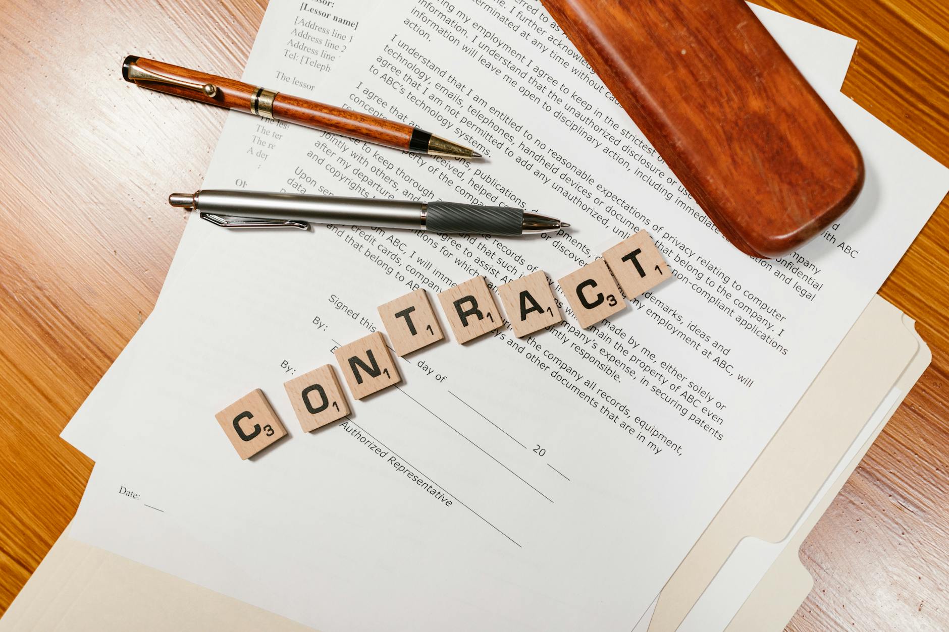 Umowa na kartkach z klockami literowymi tworzącymi napis CONTRACT