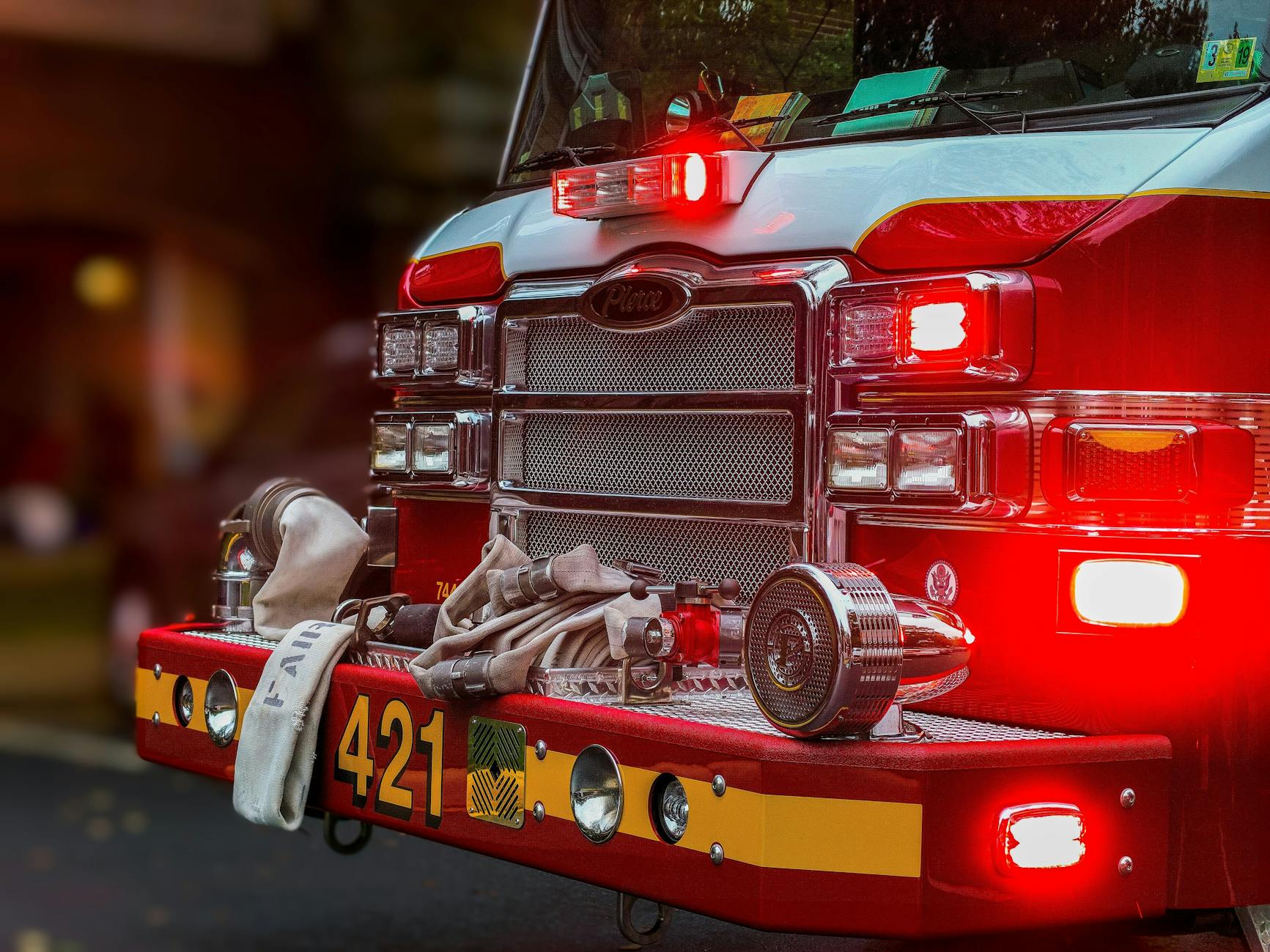 Zbliżenie zderzaka wozu strażackiego z wężami i sprzętem ratowniczym