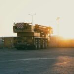 Żuraw budowlany na tle zachodu słońca na placu budowy