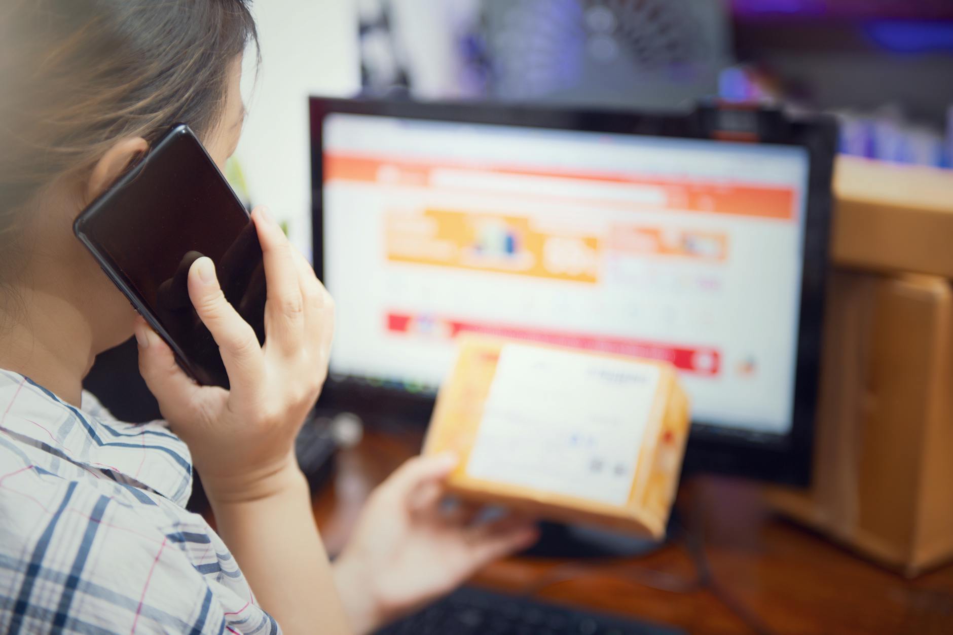 Kobieta w domu ogląda paczkę z zakupami online i dzwoni z reklamacją