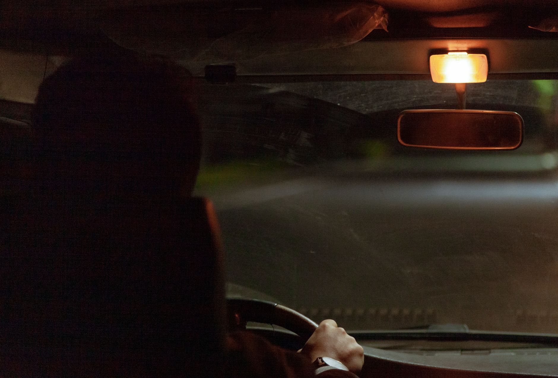 Wnętrze jadącego nocą auta oświetlone lampką sufitową